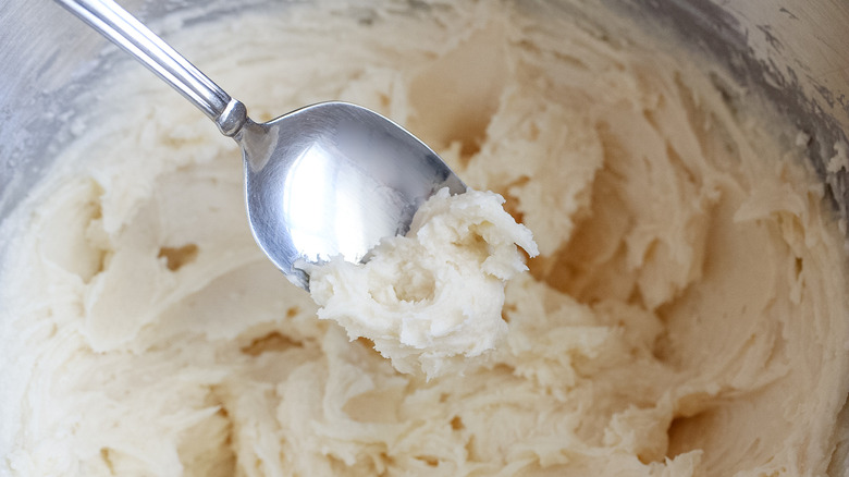 spoon scooping buttercream frosting