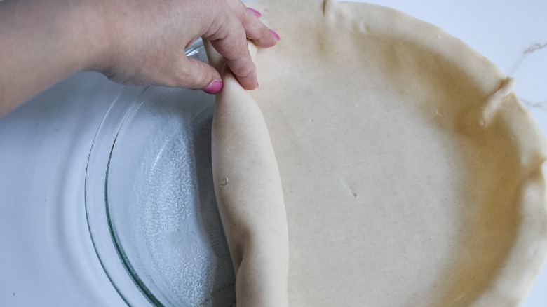 rolling pie crust onto dish