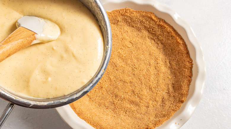 Pouring vanilla custard over graham cracker crust