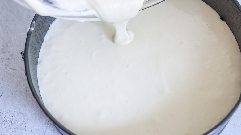 pouring creamy batter into tin