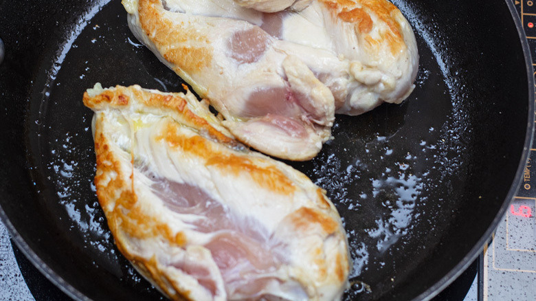 chicken searing in a skillet