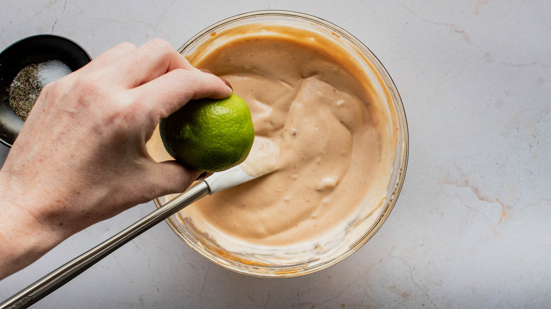 squeezing lime in chipotle mayonnaise