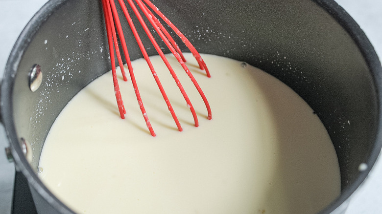 milk mixture with red whisk