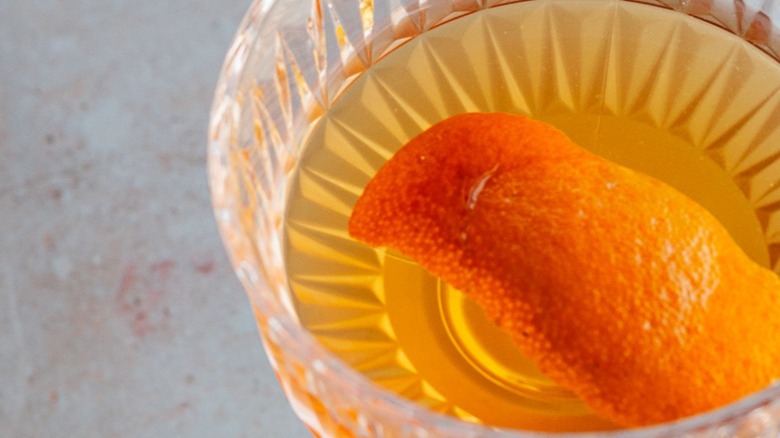 cocktail in glass with orange peel