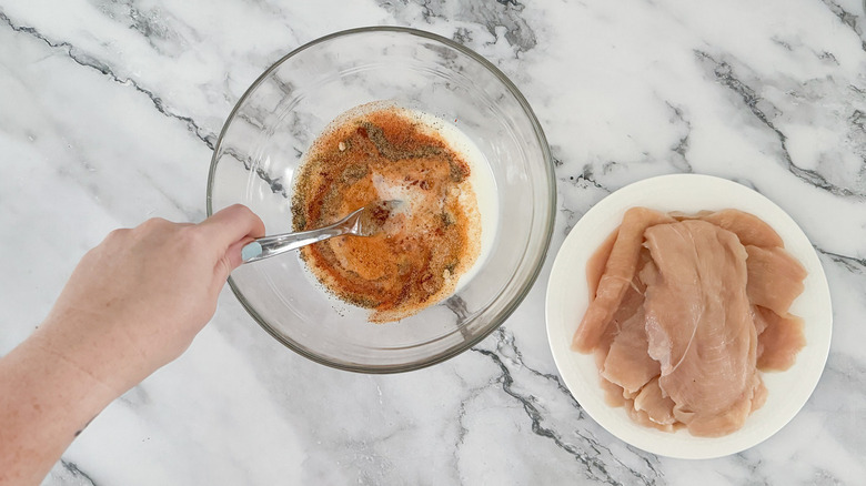 seasonings in bowl and raw chicken