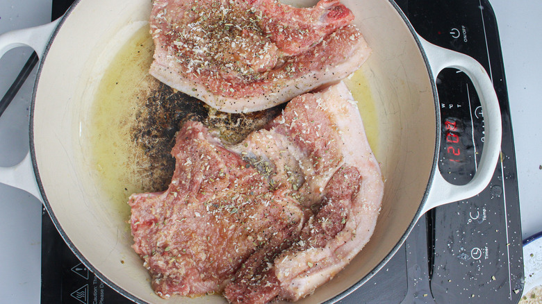 pork chops cooking in a pan