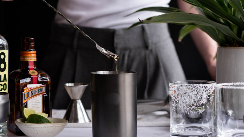 spoon dripping agave into shaker