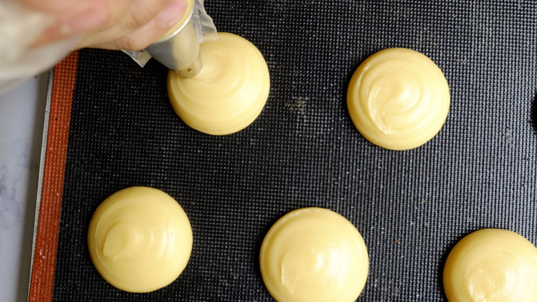 piped cream puffs on tray