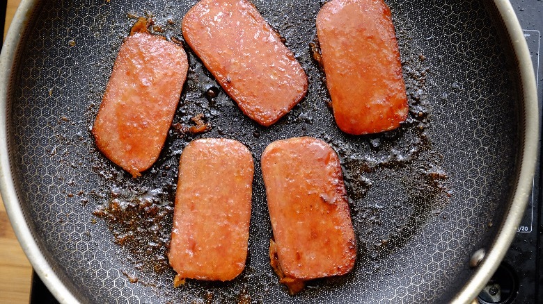 sliced spam cooking in pan