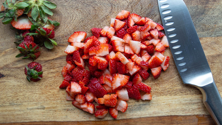 chopped strawberries on wooden board
