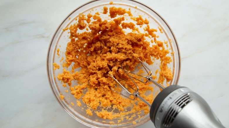 beating sweet potatoes in bowl