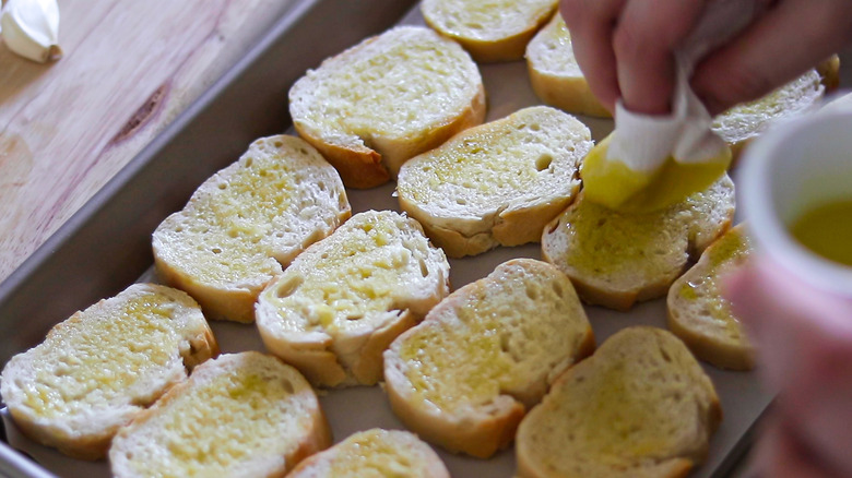 brushing bread with olive oil