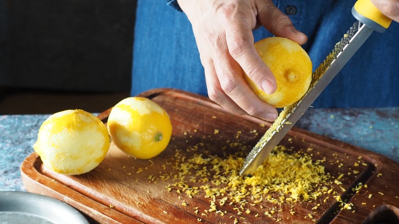 Grating lemon zest on board