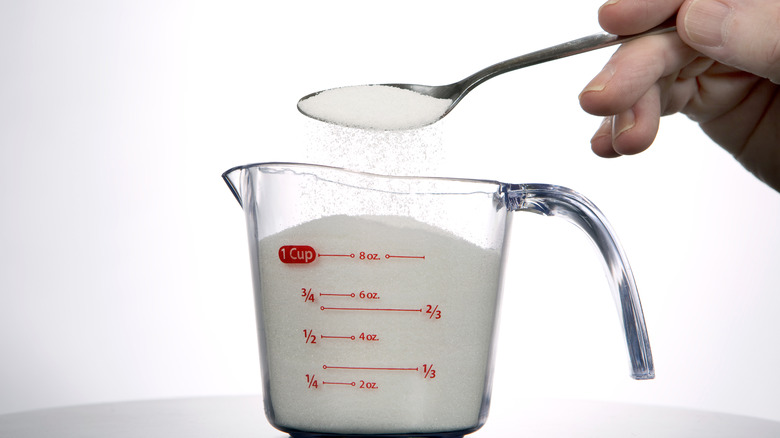 Measuring cup full of sugar