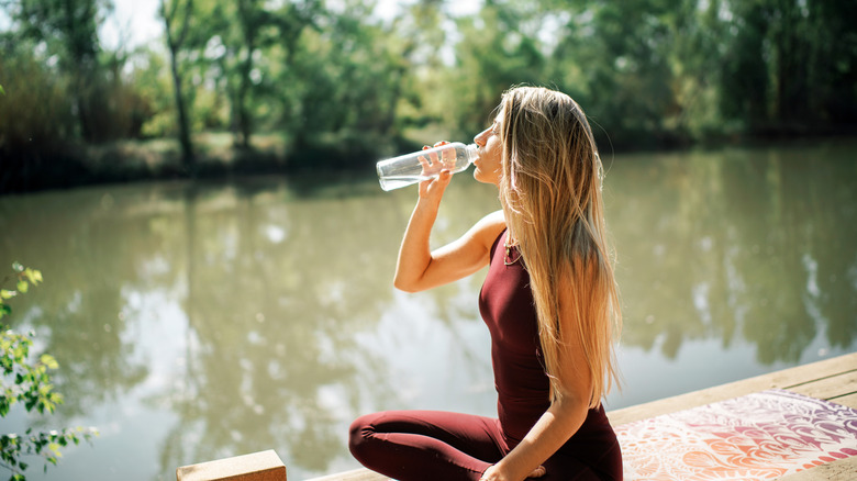 woman drinking water after yoga