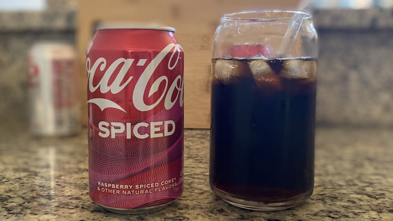 Coke Spiced poured in glass with can