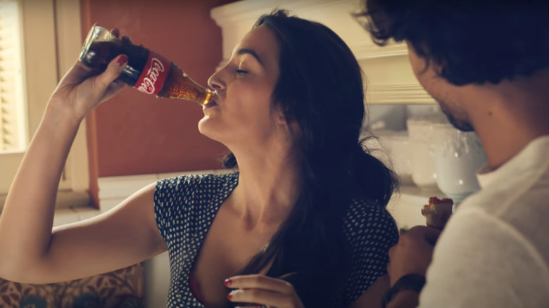 Woman drinking Coke in kitchen