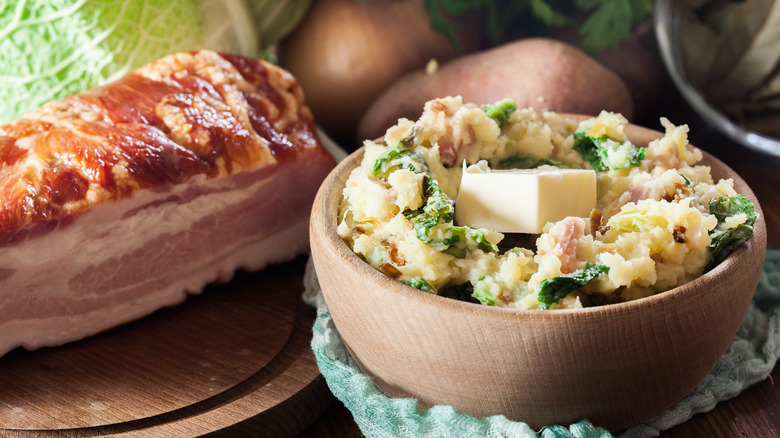 Bowl of colcannon, hunk of bacon, cabbage, and potatoes.