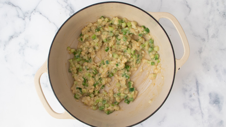 Diced vegetables coated with roux in pot