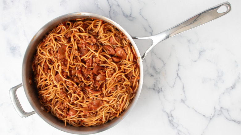 Spaghetti tossed in pork sauce with hot dogs