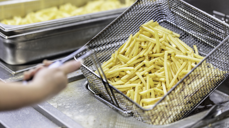 person using commercial deep fryer