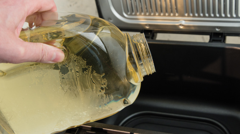 oil being poured into fryer