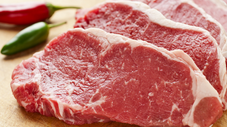 Beef on cutting board with peppers