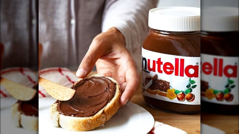 person spreading Nutella on bread