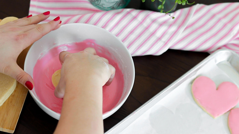 conversation heart cookie being frosted