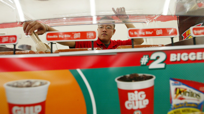 man grabbing 7-eleven hot dog