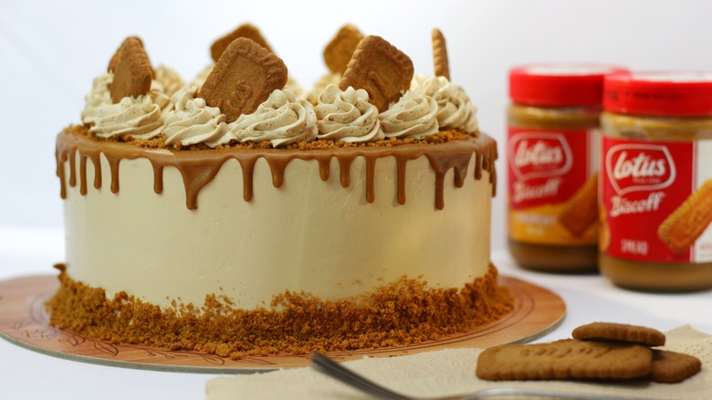 Decorated cookie butter cake with jars of biscoff spread in background