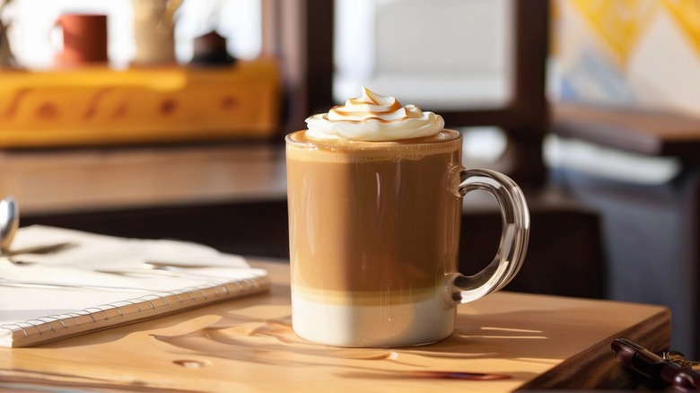 latte in glass mug on a wooden table