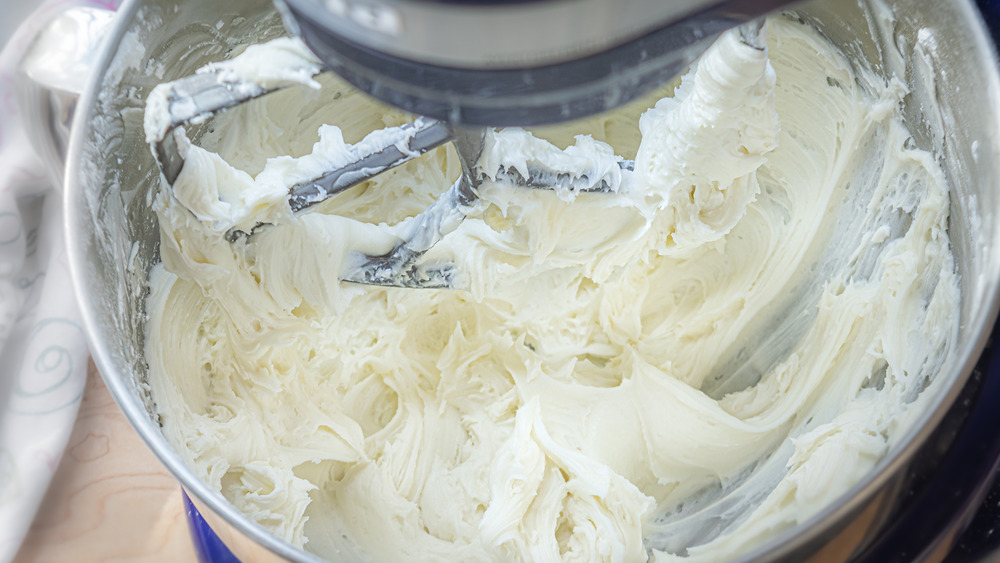 mixing buttercream frosting for this cookie cake recipe