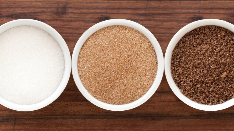 Containers of white, light brown, and dark brown sugar