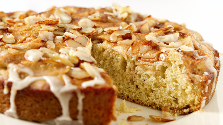 A coffee cake with laminated almonds and icing on top 