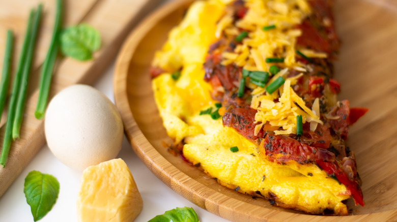 Sun-dried tomato omelet on wooden plate
