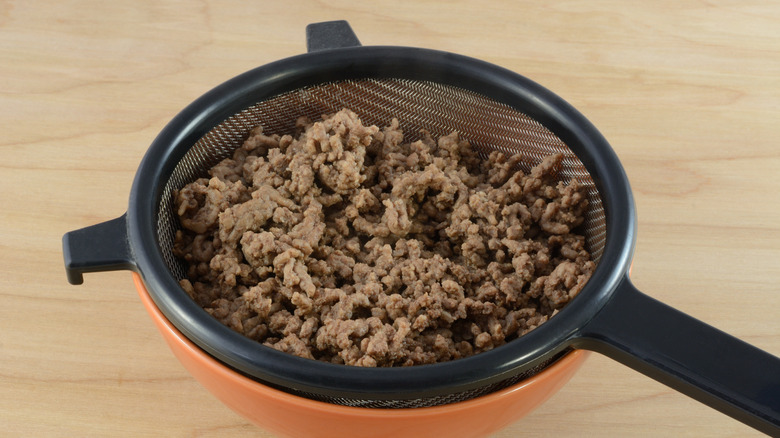 A strainer of cooked ground beef