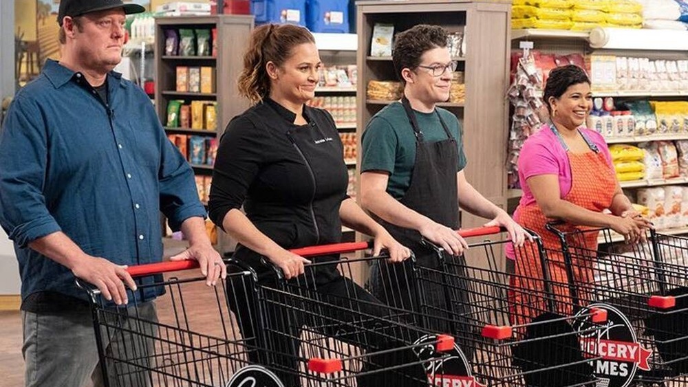 Screenshot of chefs standing with grocery carts