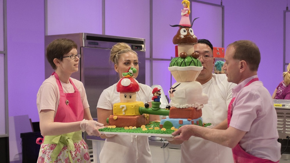 Screenshot of bakers carrying a sculpted cake