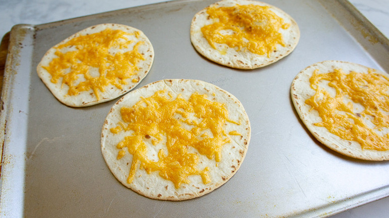 tortillas with melted cheese on a baking sheet.