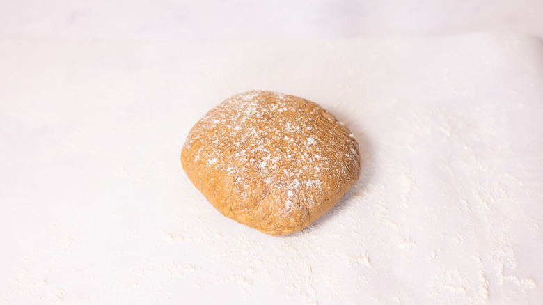 cookie dough ball dusted with flour on countertop