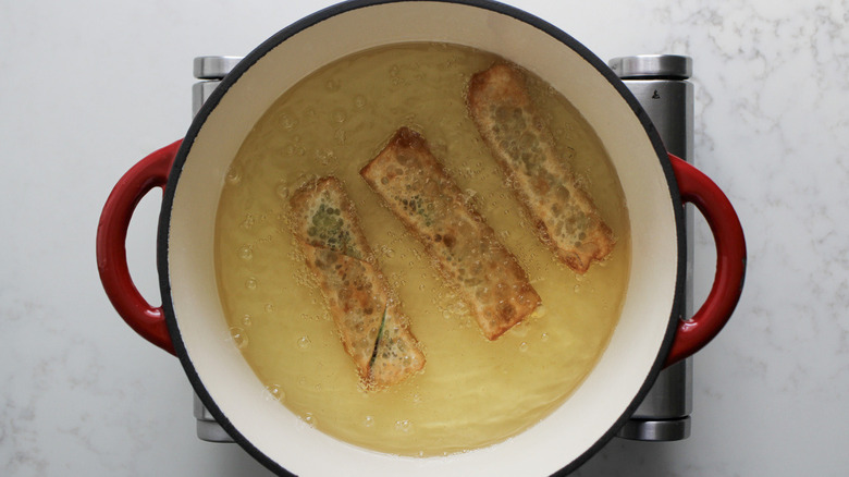 egg rolls submerged in oil