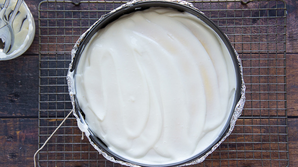 cheesecake in a springform pan on a cooling rack