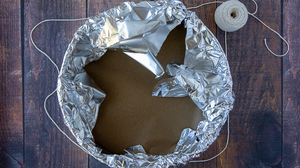 springform pan with foil being wrapped around it