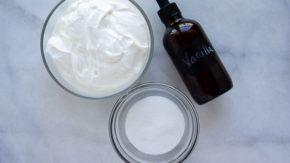 a bowl of sour cream, sugar, and a jar of vanilla