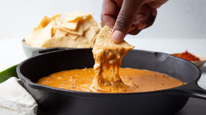 chip scooping up queso