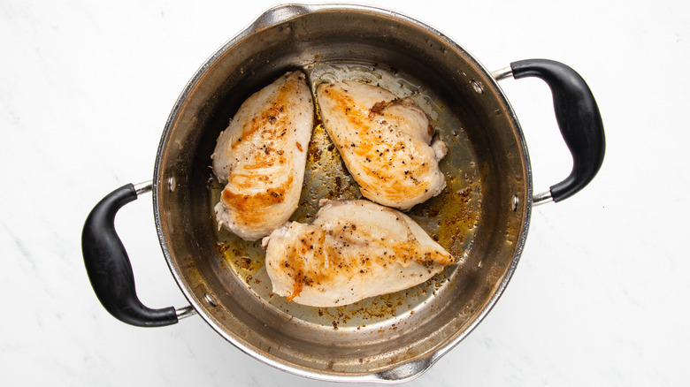 chicken breasts searing in soup pot