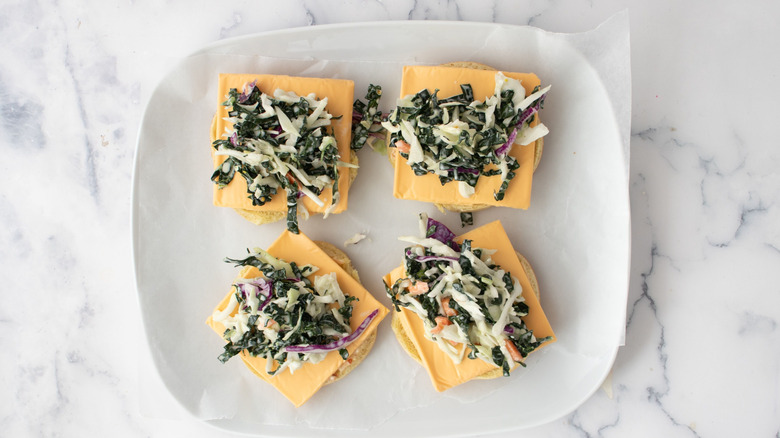 Hamburger buns with cheese and slaw on top