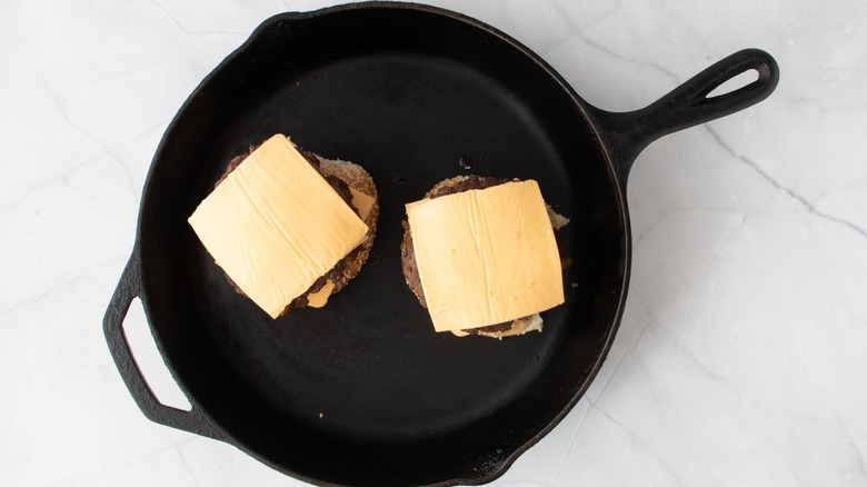 Burgers with cheese in skillet