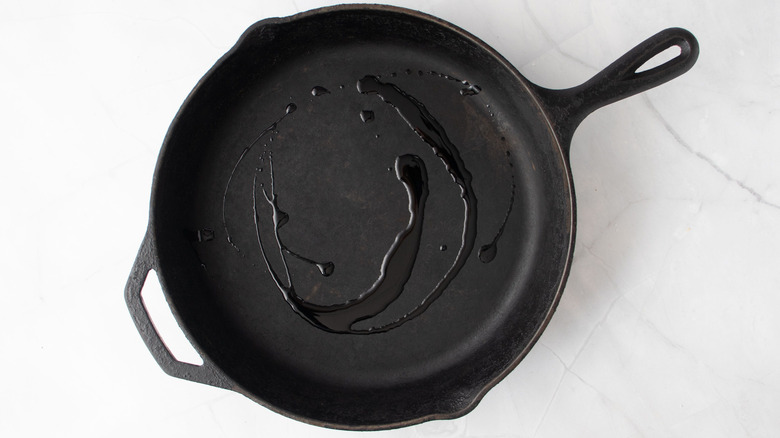 Olive oil drizzled in cast iron skillet